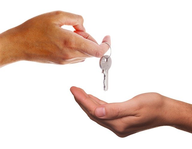 Landlord passing house keys to their new tenants